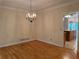 Dining room featuring hardwood floors, decorative chandelier, and view into the kitchen area at 5960 Camelia Dr, Douglasville, GA 30135