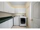 Well-lit laundry room with white cabinets, washer, and dryer for efficient chores at 5960 Camelia Dr, Douglasville, GA 30135