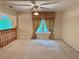 Inviting living room with neutral carpet, ceiling fan, and large window with decorative curtains at 5960 Camelia Dr, Douglasville, GA 30135