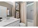 Stylish bathroom featuring modern vanity with white countertop, framed art, and a tiled shower/tub combo with neutral curtain at 133 Frontier Way, Mcdonough, GA 30253