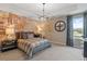 Comfortable bedroom with a plaid comforter, a stylish accent wall, and natural light from the window at 133 Frontier Way, Mcdonough, GA 30253