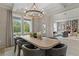 Airy dining area with large windows, modern chandelier, and decorative centerpieces at 133 Frontier Way, Mcdonough, GA 30253