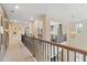 Open second-story hallway with decorative railing overlooking the living room and natural light from the window at 133 Frontier Way, Mcdonough, GA 30253