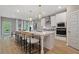 Modern kitchen featuring a large island with seating, white cabinetry, stainless steel appliances and wooden floor at 133 Frontier Way, Mcdonough, GA 30253
