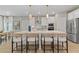 Modern kitchen with island seating, white cabinets, stainless steel appliances, hardwood flooring and modern lighting at 133 Frontier Way, Mcdonough, GA 30253