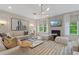 Elegant living room featuring a fireplace, modern decor, comfortable seating, and large windows offering abundant natural light at 133 Frontier Way, Mcdonough, GA 30253