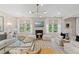 Bright living room featuring modern fireplace, plush seating arrangements, decorative lighting, and lots of natural light at 133 Frontier Way, Mcdonough, GA 30253
