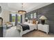 Comfortable main bedroom featuring an upholstered bed and decorative lighting at 133 Frontier Way, Mcdonough, GA 30253