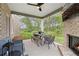 Covered outdoor patio area with a fireplace and wooded backyard at 133 Frontier Way, Mcdonough, GA 30253