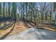Large backyard with mature trees and a concrete patio for outdoor enjoyment at 2111 Glenwood Downs Dr, Decatur, GA 30035