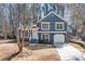 Charming two-story home with blue siding, white trim, an attached garage and well-maintained landscaping at 2111 Glenwood Downs Dr, Decatur, GA 30035