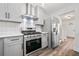 Modern kitchen with stainless steel appliances, gray cabinets, white backsplash, and hardwood floors at 2111 Glenwood Downs Dr, Decatur, GA 30035
