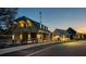 Inviting street view of new homes in a neighborhood at dusk with warm exterior lighting and landscaping at 51 Hydrangea Unit 74 Way, Auburn, GA 30011
