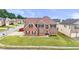 Inviting two-story brick home featuring a manicured lawn, arched entryway, and symmetrical window placement at 106 Dustin Dr, Stockbridge, GA 30281
