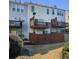 Rear exterior view of multi-story townhomes with decks and fenced yards at 113 Brianna Way, Woodstock, GA 30188