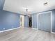 Spacious bedroom with blue walls, wood floors, and a double door closet at 150 Forest Ridge Ct, Lawrenceville, GA 30046