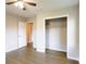 Light-filled bedroom with a ceiling fan, hardwood floors, closet, and a view into an adjacent room at 391 Oak Dr, Social Circle, GA 30025