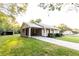 Exterior view of home with covered parking and a long driveway, surrounded by a lush green lawn at 391 Oak Dr, Social Circle, GA 30025