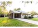 Well-maintained exterior of gray brick home with a covered parking area and a concrete driveway at 391 Oak Dr, Social Circle, GA 30025