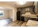 Well-lit kitchen with gray cabinets, granite countertops, and durable gray-toned laminate flooring at 391 Oak Dr, Social Circle, GA 30025