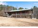 Charming log cabin with a covered front porch and a metal roof, surrounded by a spacious yard at 5256 Kilroy Ln, Douglasville, GA 30135