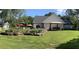 Backyard view featuring a spacious lawn, garden, and patio area with outdoor seating under umbrellas at 105 Crown Ln, Woodstock, GA 30188