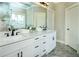 Bright bathroom featuring double sink vanity with white cabinetry, black hardware and marble tile flooring at 105 Crown Ln, Woodstock, GA 30188