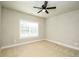 Bright bedroom featuring neutral carpet, a ceiling fan, and a window offering natural light at 105 Crown Ln, Woodstock, GA 30188