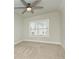 Bedroom with neutral carpet, ceiling fan, and a window offering ample natural light at 105 Crown Ln, Woodstock, GA 30188