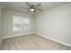 Cozy bedroom features neutral carpet, a ceiling fan, and a window offering ample natural light at 105 Crown Ln, Woodstock, GA 30188