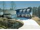 Beautiful white farmhouse with metal roof, dormers, three-car garage and long concrete driveway at 105 Crown Ln, Woodstock, GA 30188