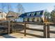 Charming white farmhouse with a metal roof, dormers, and a wooden fence surrounding the landscaped yard at 105 Crown Ln, Woodstock, GA 30188