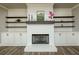 Elegant fireplace featuring white painted brick, custom shelving and cabinets at 105 Crown Ln, Woodstock, GA 30188