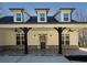 Inviting craftsman-style porch featuring dark wood pillars, ceiling fans, and a brick floor at 105 Crown Ln, Woodstock, GA 30188