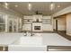 Kitchen showing the farmhouse sink, stainless steel appliances, and views into the open-concept living area at 105 Crown Ln, Woodstock, GA 30188