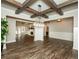 Open-concept living space with wood floors, coffered ceilings, and a seamless flow to the kitchen at 105 Crown Ln, Woodstock, GA 30188