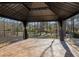 Covered outdoor patio featuring decorative stamped concrete and tranquil views of the surrounding wooded area at 105 Crown Ln, Woodstock, GA 30188