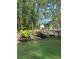 Gorgeous backyard pool area featuring rock waterfall and lush landscaping at 105 Crown Ln, Woodstock, GA 30188