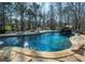 Beautifully landscaped pool with a waterfall feature and natural stone surround, offering a relaxing backyard oasis at 105 Crown Ln, Woodstock, GA 30188