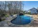 Backyard oasis featuring a freeform pool, waterfall feature, and natural stone landscaping at 105 Crown Ln, Woodstock, GA 30188