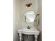 A half-bathroom with a pedestal sink and oval mirror is illuminated by decorative lights at 105 Crown Ln, Woodstock, GA 30188