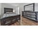 Well-lit bedroom showcasing a queen-size bed and dresser, complemented by hardwood floors and neutral tones at 6700 Roswell Rd # 24E, Atlanta, GA 30328