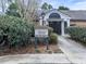 Community clubhouse and pool sign surrounded by manicured bushes at 6700 Roswell Rd # 24E, Atlanta, GA 30328