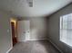 This bedroom features neutral walls, plush carpet, and a window for natural light at 885 Hemingway Rd, Stone Mountain, GA 30088