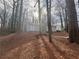 Single-story gray home nestled in a wooded area, featuring a sliding glass door and steps to the front entrance at 5073 Martins Crossing Rd, Stone Mountain, GA 30088