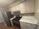 Compact kitchen featuring stainless steel appliances, white countertops, and ample cabinet storage at 5073 Martins Crossing Rd, Stone Mountain, GA 30088