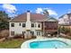 Back exterior of home with screened porch overlooking a private pool and well-maintained backyard at 635 Piping Rock Pt, Lawrenceville, GA 30043