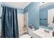 Bathroom featuring a shower-tub combo with curtain, a vanity, and light blue walls at 635 Piping Rock Pt, Lawrenceville, GA 30043