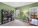 Green bedroom filled with natural light from two windows, a bookcase, and a comfortable workspace at 635 Piping Rock Pt, Lawrenceville, GA 30043