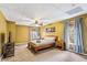 Cozy bedroom featuring a wooden frame bed, warm color walls, ceiling fan, and two windows with coverings at 635 Piping Rock Pt, Lawrenceville, GA 30043